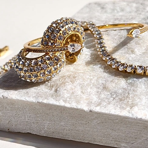gold plated jewelry with stone accents shining in the sun