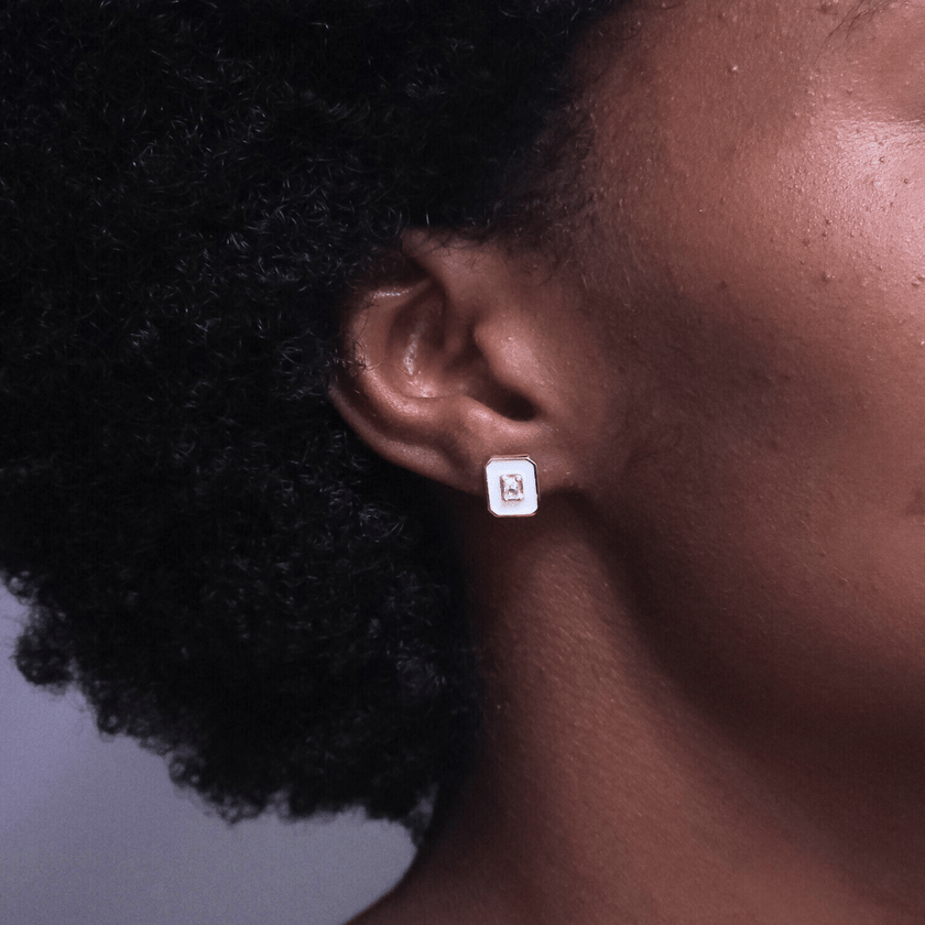 stunning pair of white shell accent stud earrings made with 14 karat gold plated sterling silver featuring a sparkling center crystal stone