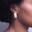 girl wearing chunky statement semi hoop earrings covered in crystal stones made with 18 karat gold plated stainless steel