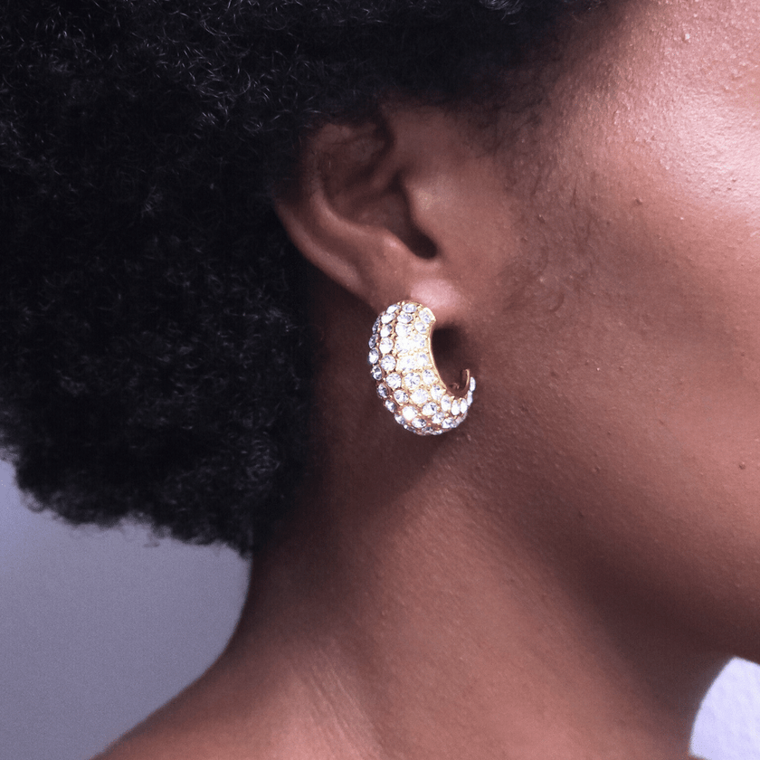 close up of chunky statement semi hoop earrings covered in crystal stones made with 18 karat gold plated stainless steel