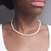 girl wearing necklace made of single string of white freshwater pearls and sterling silver plated with 14 karat gold