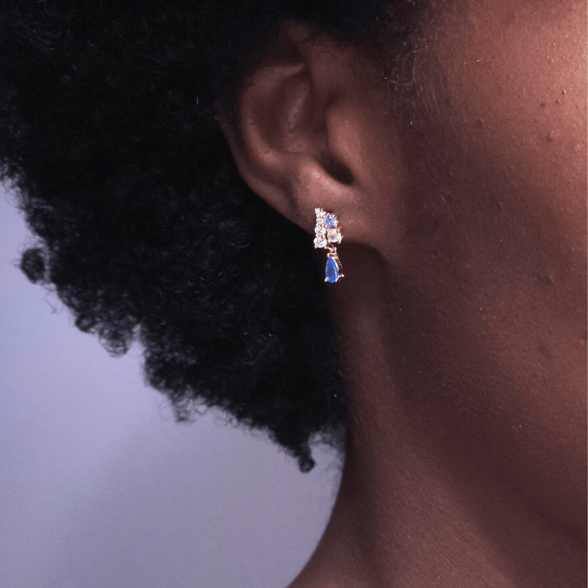 close up of girl wearing pink and blue crystal dangle earrings benefitting the jack and jill of America foundation