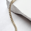 Gold bracelet with diamonds on a white stone surface